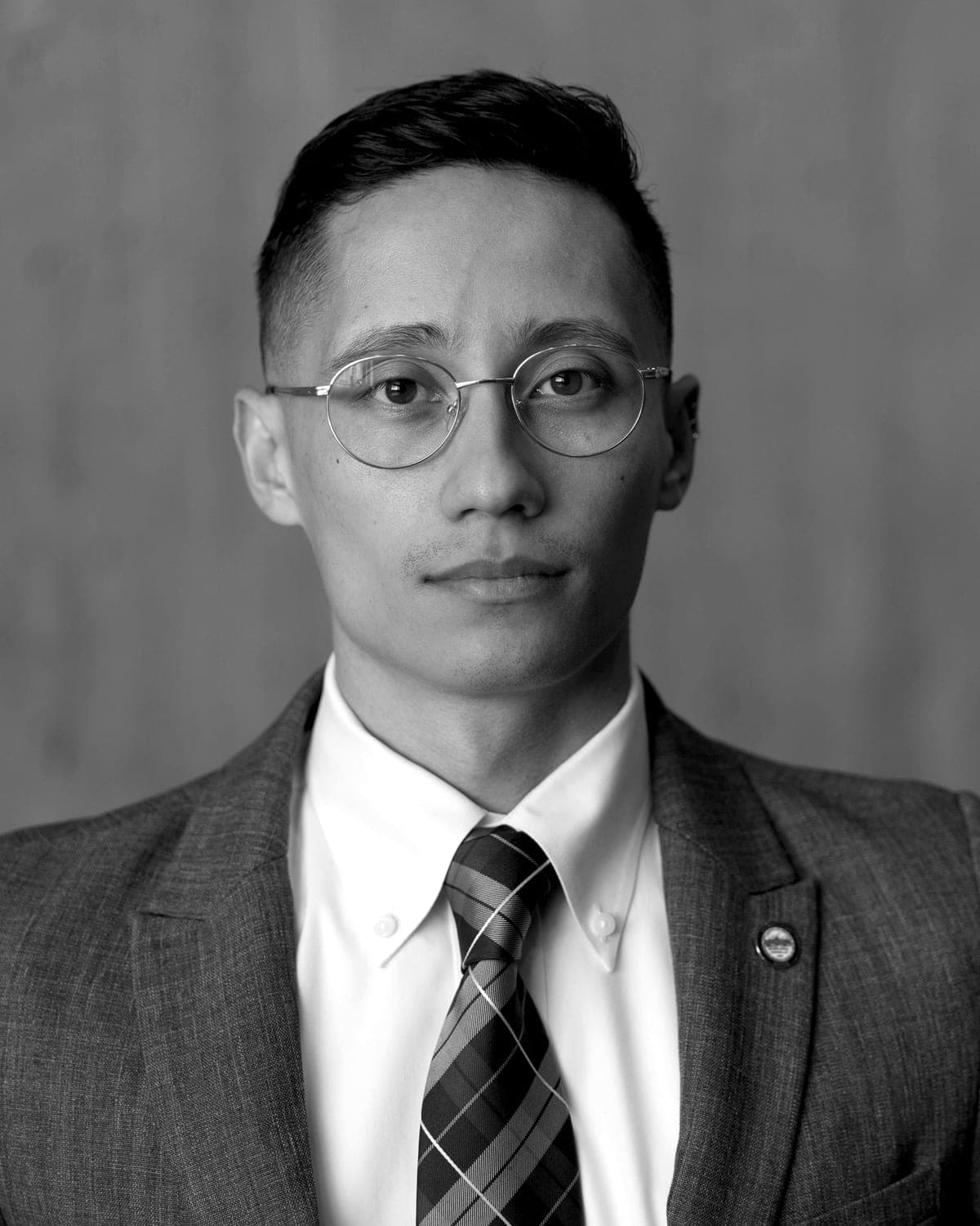 Portrait of Ezra Zwaeli in a suit and round glasses